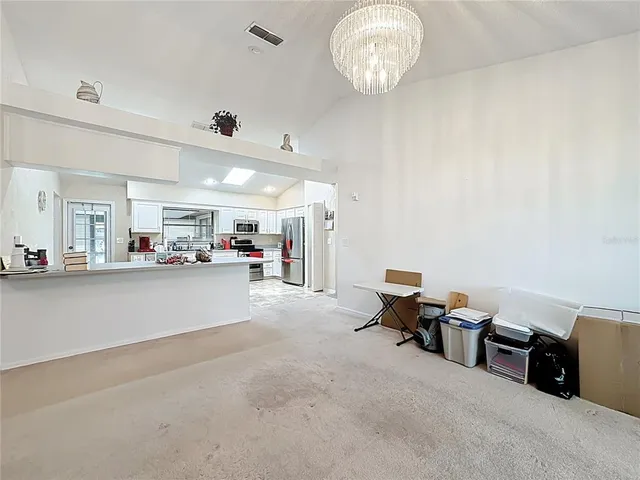 a bedroom with a bed chandelier and a window