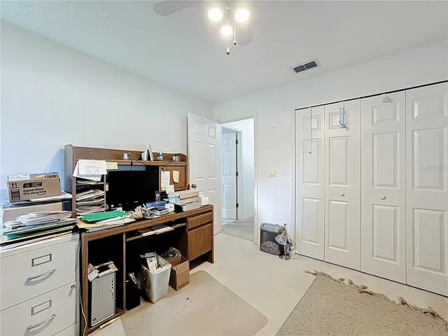 a view of a workspace with furniture and a ceiling fan