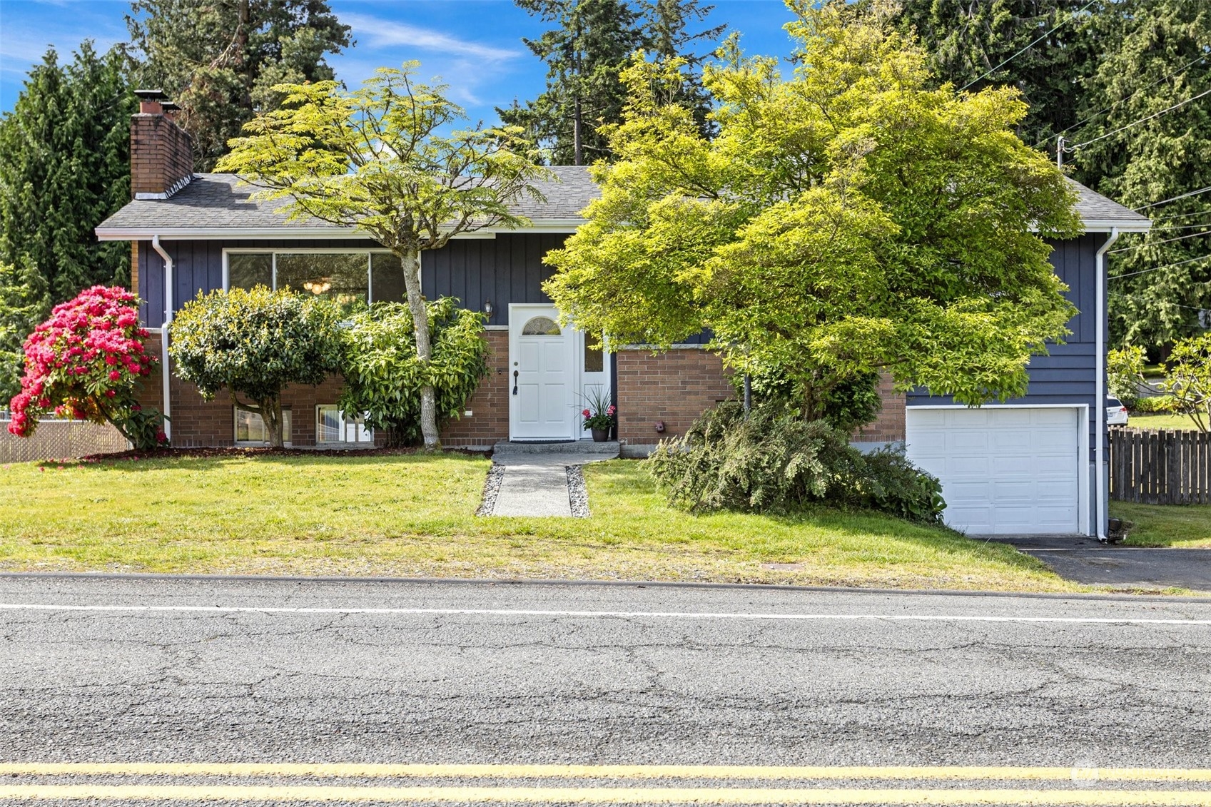 a view of yellow house with a yard and sitting area