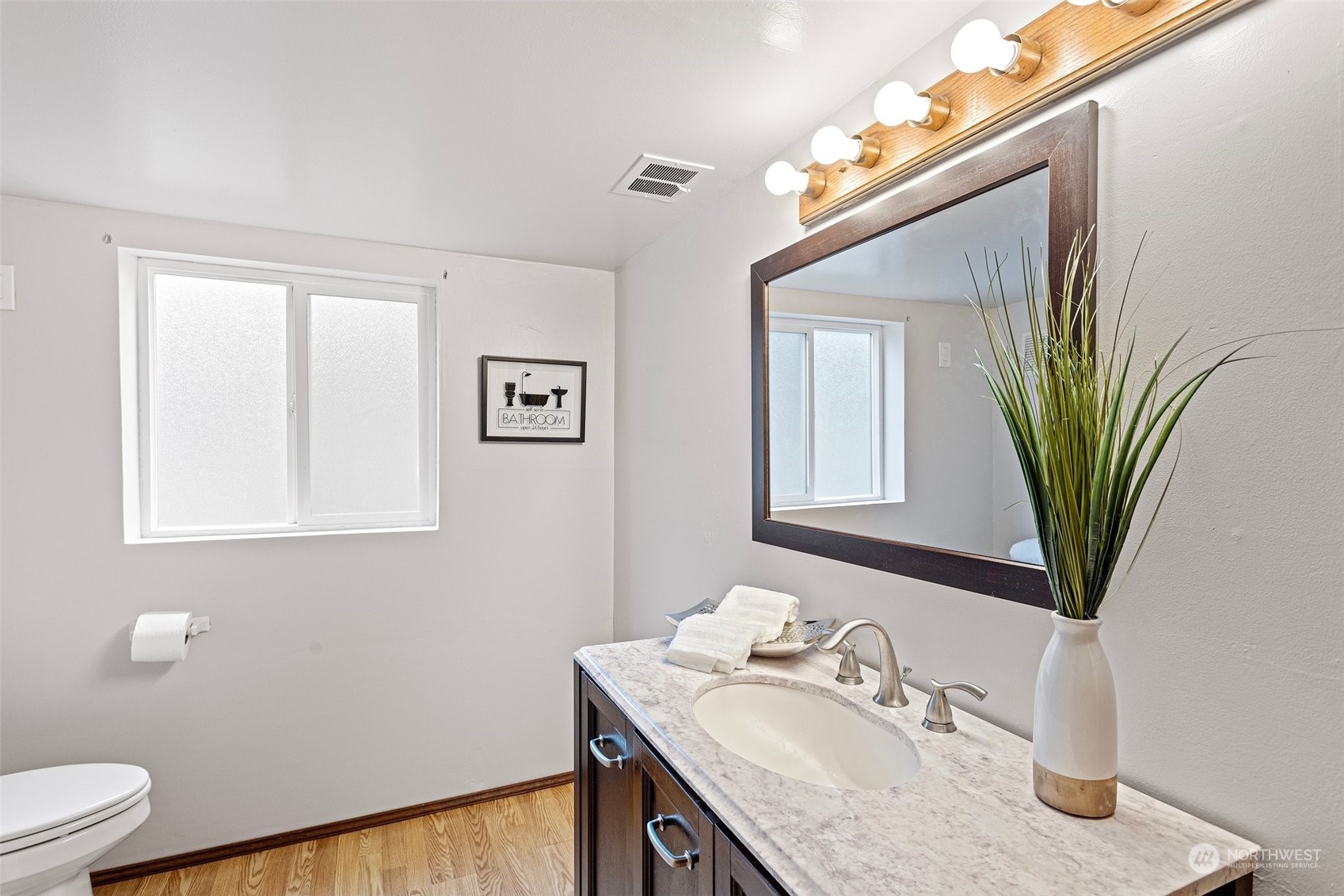 331 North 200th Street Shoreline, WA 98133 - Photo 22 of 28 a bathroom with a granite countertop sink a mirror and a toilet