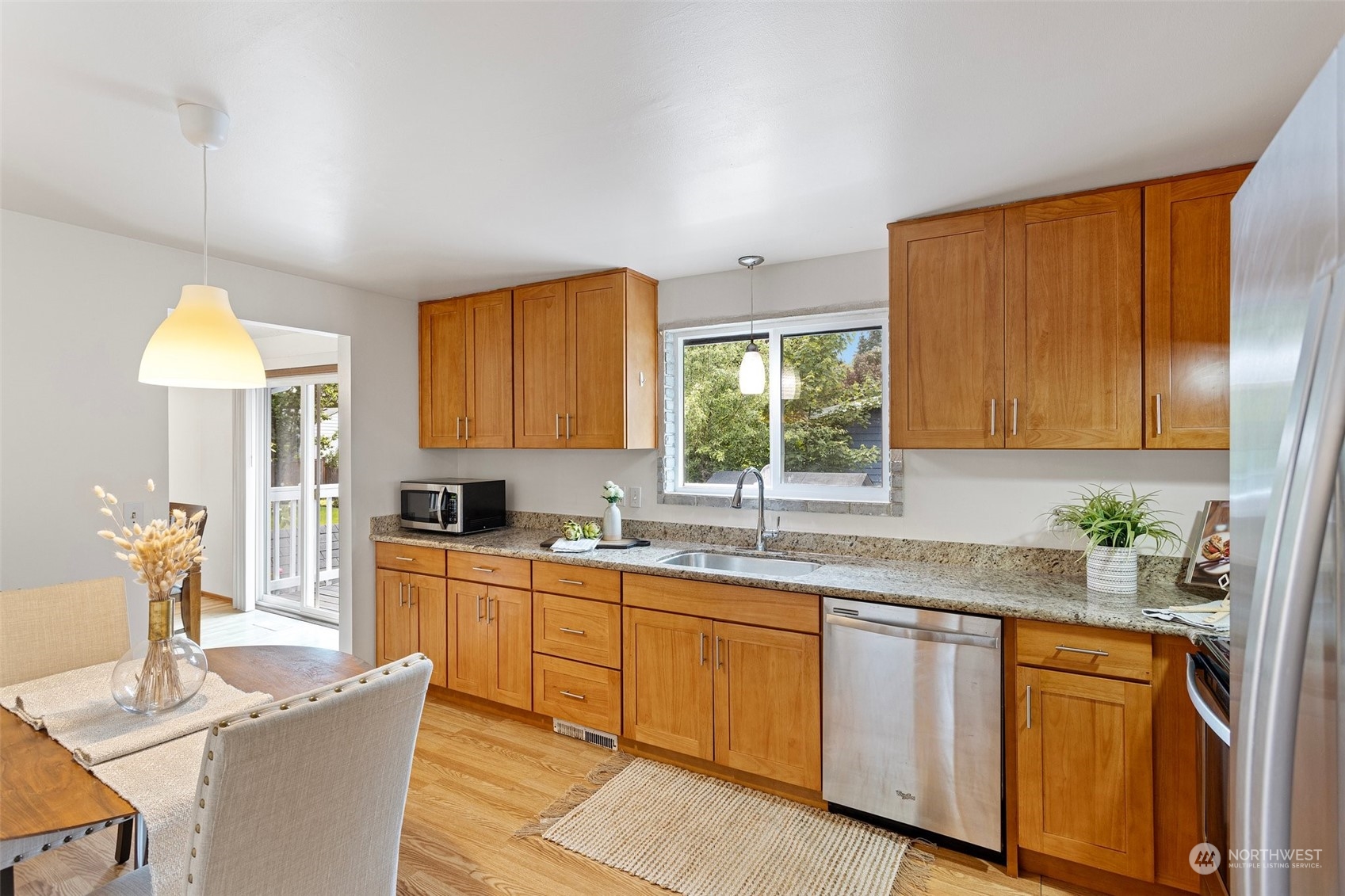 331 North 200th Street Shoreline, WA 98133 - Photo 10 of 28 a kitchen with stainless steel appliances granite countertop wooden cabinets a sink a stove a dining table and chairs