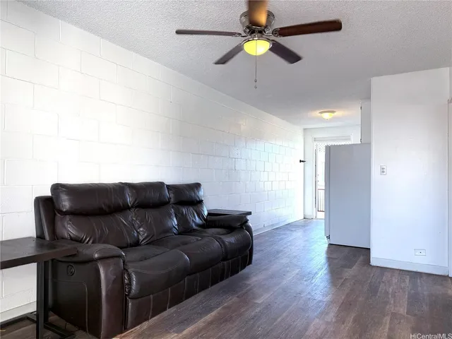 a living room with furniture and a ceiling fan