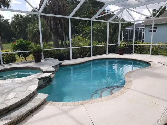 a view of a backyard with swimming pool and sitting area