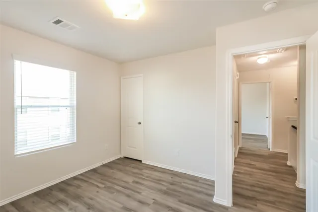 a view of an empty room with wooden floor