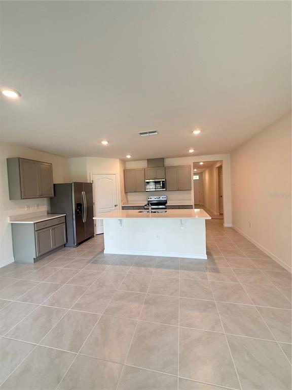 216 Taylor Groves St Lake Lake Wales, FL 33898 - Photo 2 of 18 a large white kitchen with kitchen island a sink a counter top stainless steel appliances and cabinets