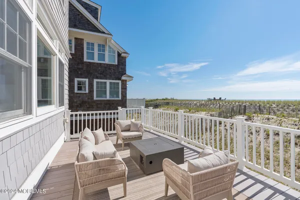 a large kitchen with kitchen island granite countertop a stove a sink a refrigerator and white cabinets with wooden floor
