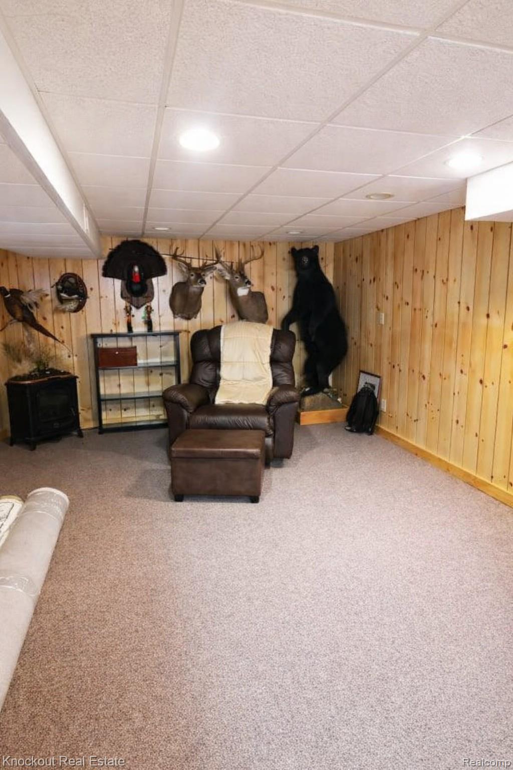 8980 Curtis Road Frankenmuth, MI 48734 - Photo 31 of 56 Living room featuring a drop ceiling, wooden walls, and carpet flooring