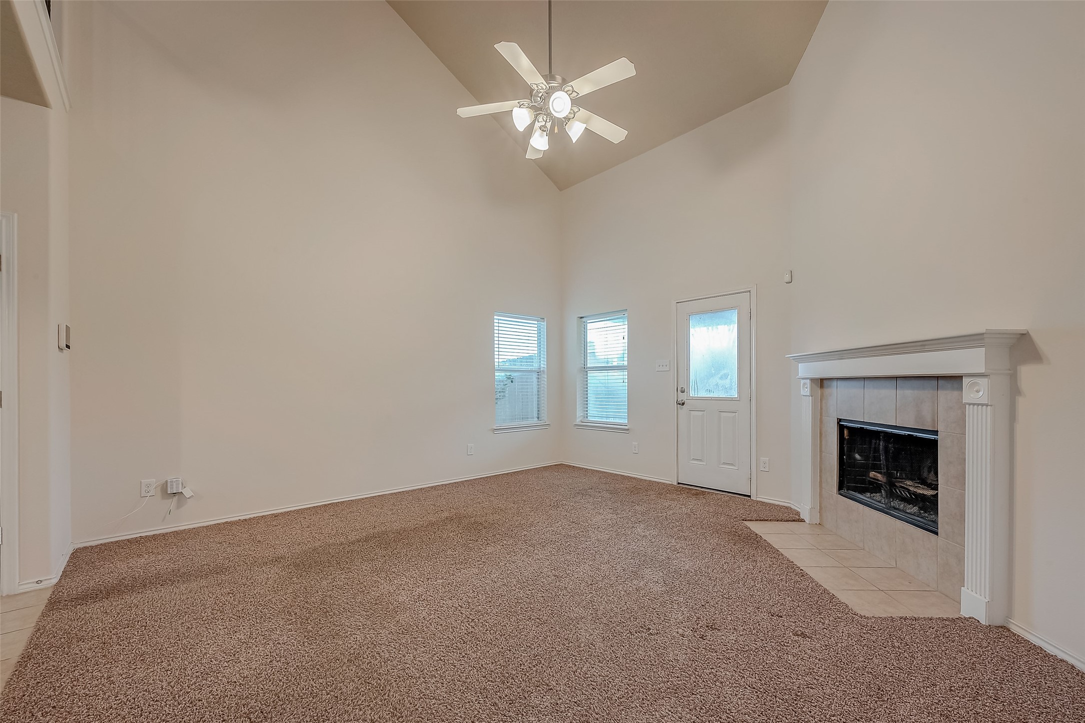 21203 Branchport Drive Houston, TX 77095 - Photo 17 of 49 an empty room with chandelier fan and fireplace