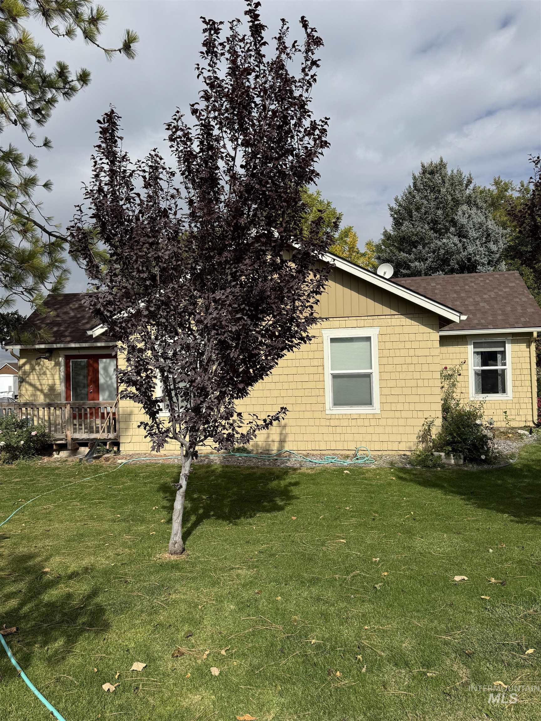 9101 South Powerline Road Nampa, ID 83686 - Photo 4 of 12 View of side of property featuring a lawn and roof with shingles