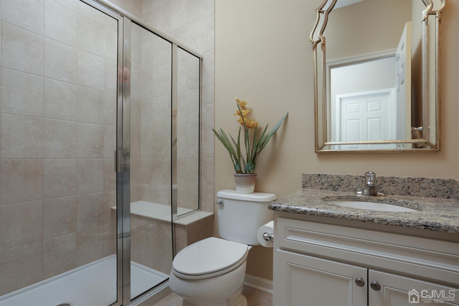 28 Harvest Ridge Road Howell, NJ 07731 - Photo 17 of 27 The second bath has a stall shower with seat, and a granite countertop on the vanity.
