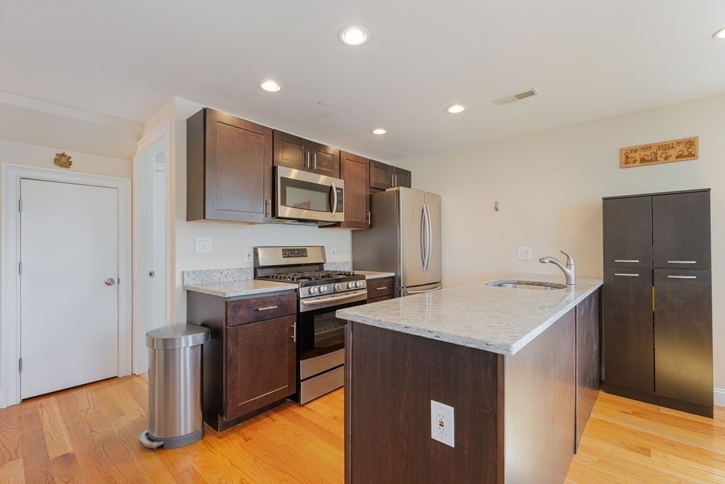 129 Spring Street, Unit 3 Cambridge, MA 02141 - Photo 2 of 17 a kitchen with stainless steel appliances a stove refrigerator sink and microwave