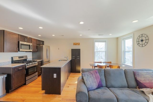 a living room with stainless steel appliances granite countertop furniture and a window