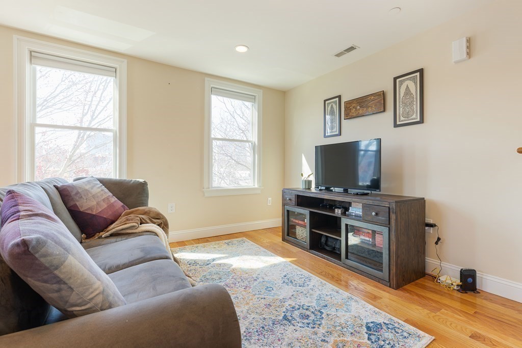 129 Spring Street, Unit 3 Cambridge, MA 02141 - Photo 6 of 17 a living room with furniture and a flat screen tv