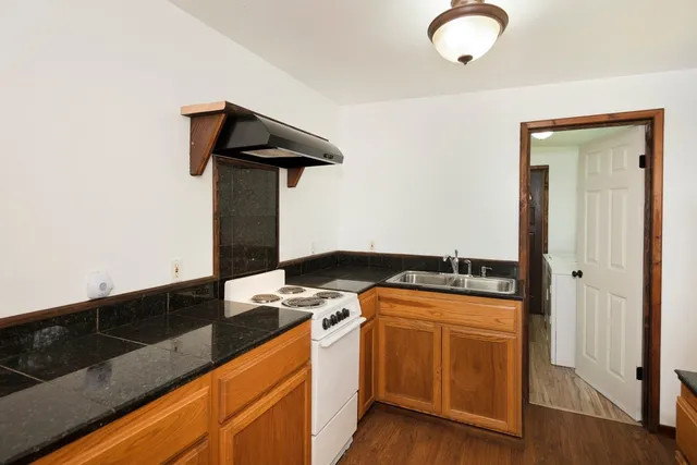 a kitchen with stainless steel appliances granite countertop a stove a sink and a refrigerator
