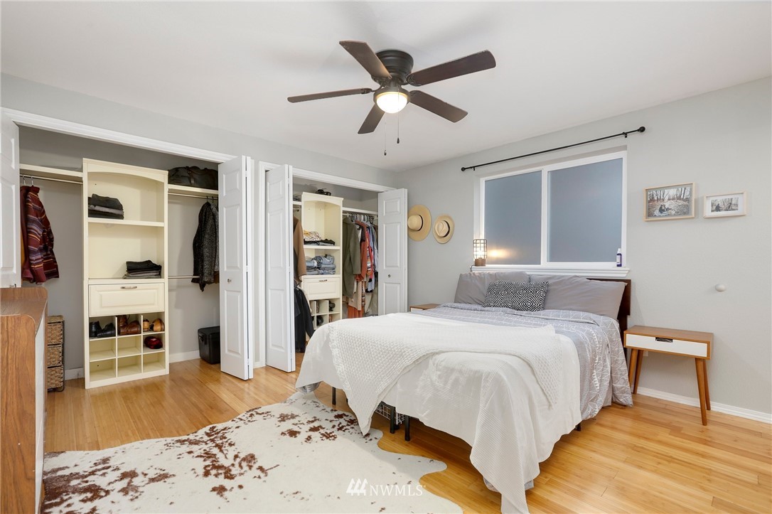 1701 174th Place Southeast Bothell, WA 98012 - Photo 19 of 40 a spacious bedroom with a bed and dresser with wooden floor