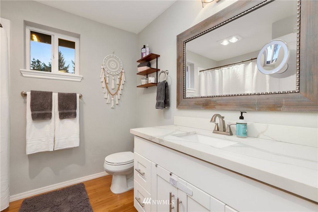 1701 174th Place Southeast Bothell, WA 98012 - Photo 23 of 40 a bathroom with a granite countertop toilet sink and mirror