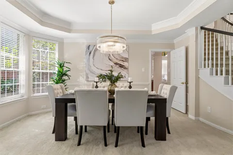 a dining room with furniture a potted plant and a chandelier