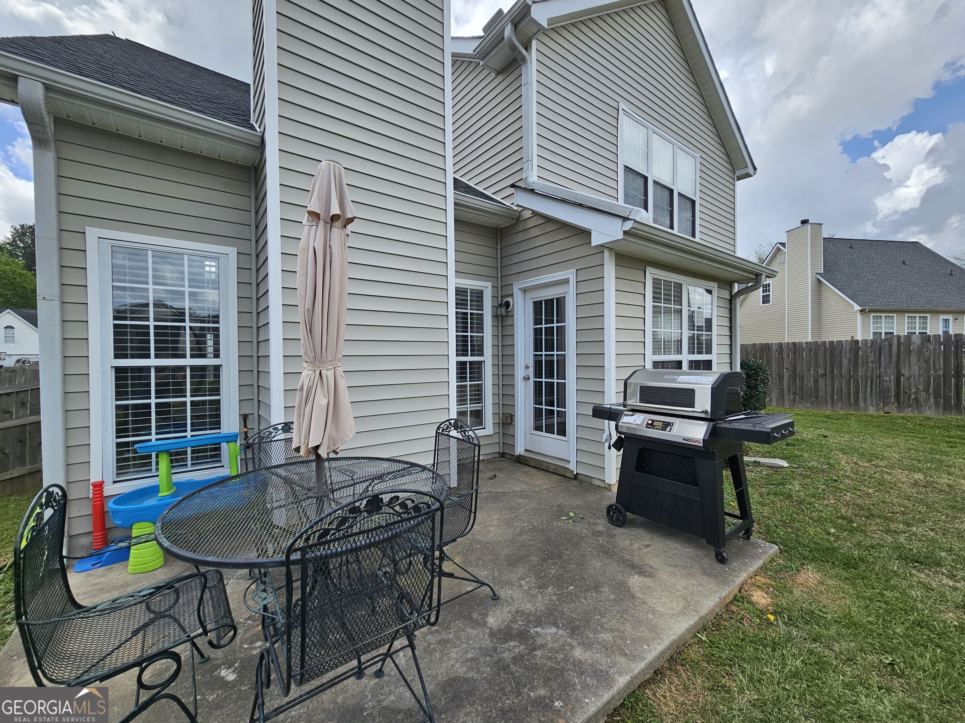 5077 Meadow Trace Fairburn, GA 30213 - Photo 16 of 43 a backyard of a house with wooden chairs and a table