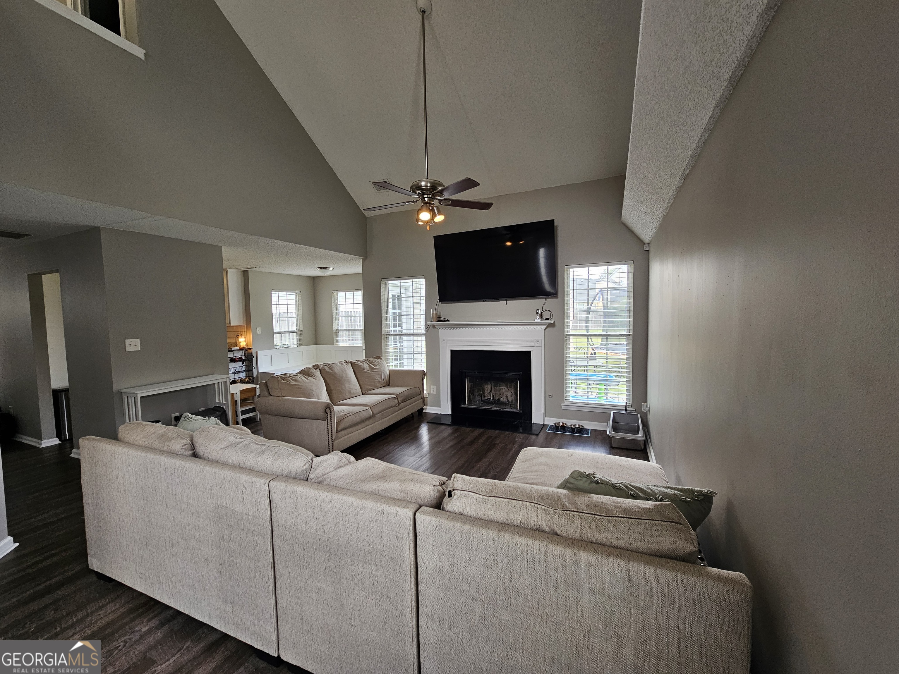 5077 Meadow Trace Fairburn, GA 30213 - Photo 18 of 43 a living room with furniture a fireplace and a flat screen tv