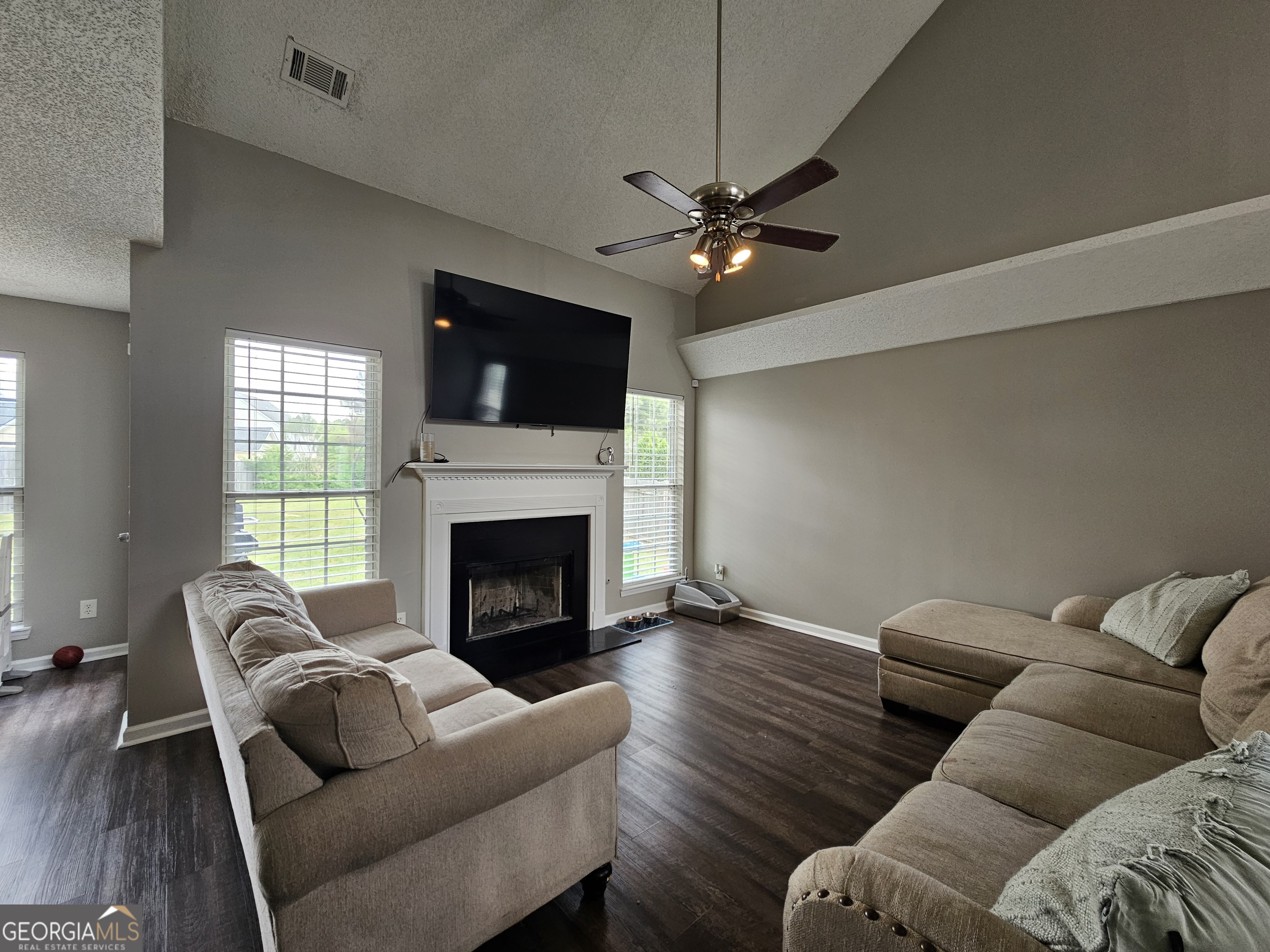 5077 Meadow Trace Fairburn, GA 30213 - Photo 19 of 43 a living room with furniture a flat screen tv and a fireplace