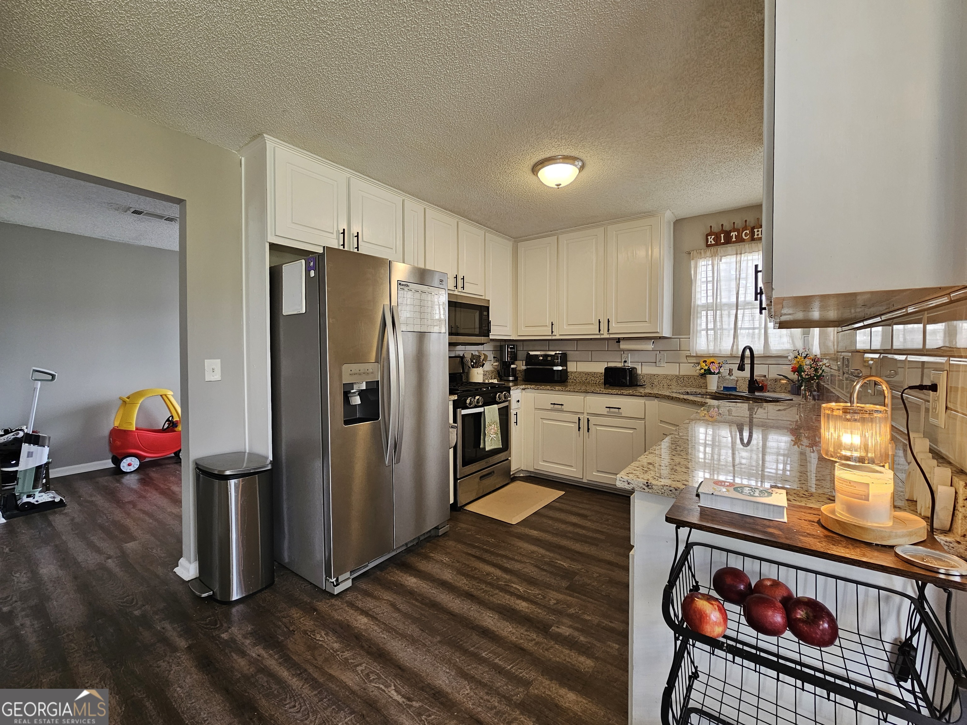 5077 Meadow Trace Fairburn, GA 30213 - Photo 26 of 43 a kitchen with stainless steel appliances granite countertop a refrigerator a stove and a sink with wooden floor