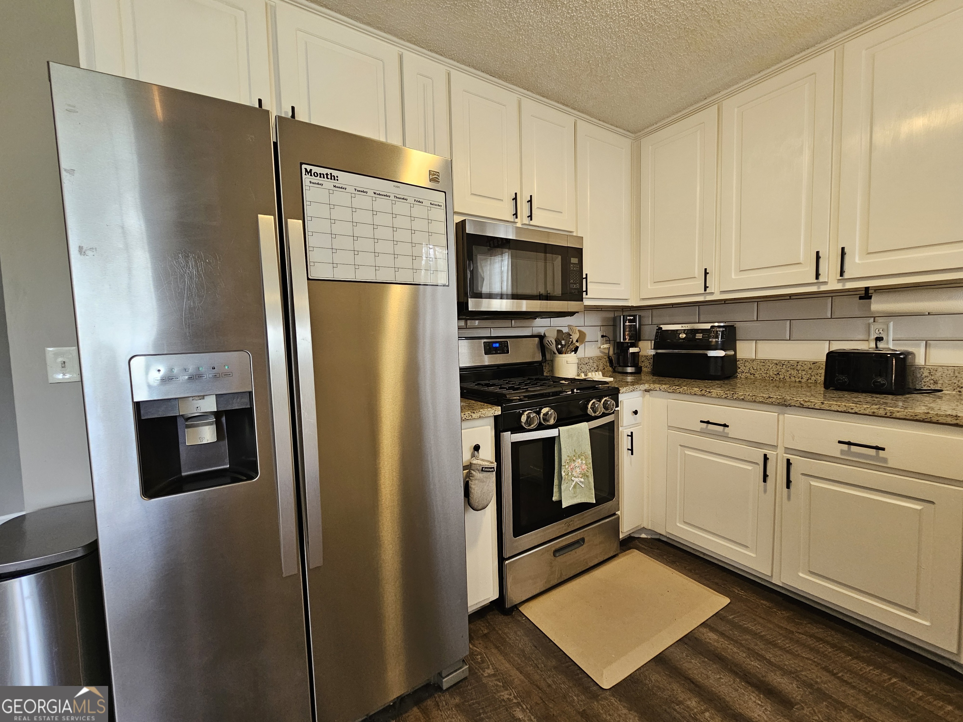 5077 Meadow Trace Fairburn, GA 30213 - Photo 30 of 43 a kitchen with stainless steel appliances a refrigerator sink and microwave