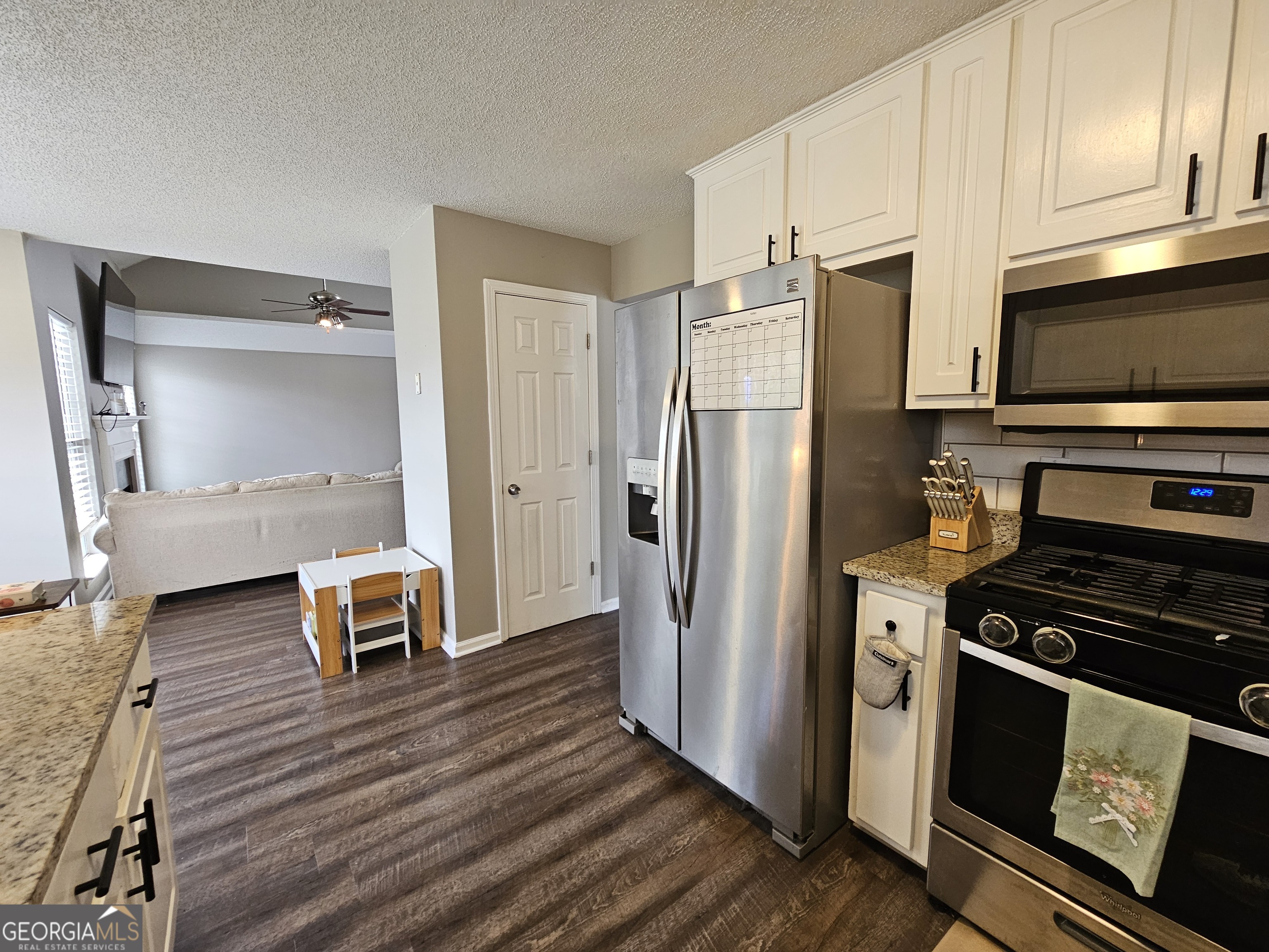 5077 Meadow Trace Fairburn, GA 30213 - Photo 32 of 43 a kitchen with stainless steel appliances a stove a refrigerator and cabinets