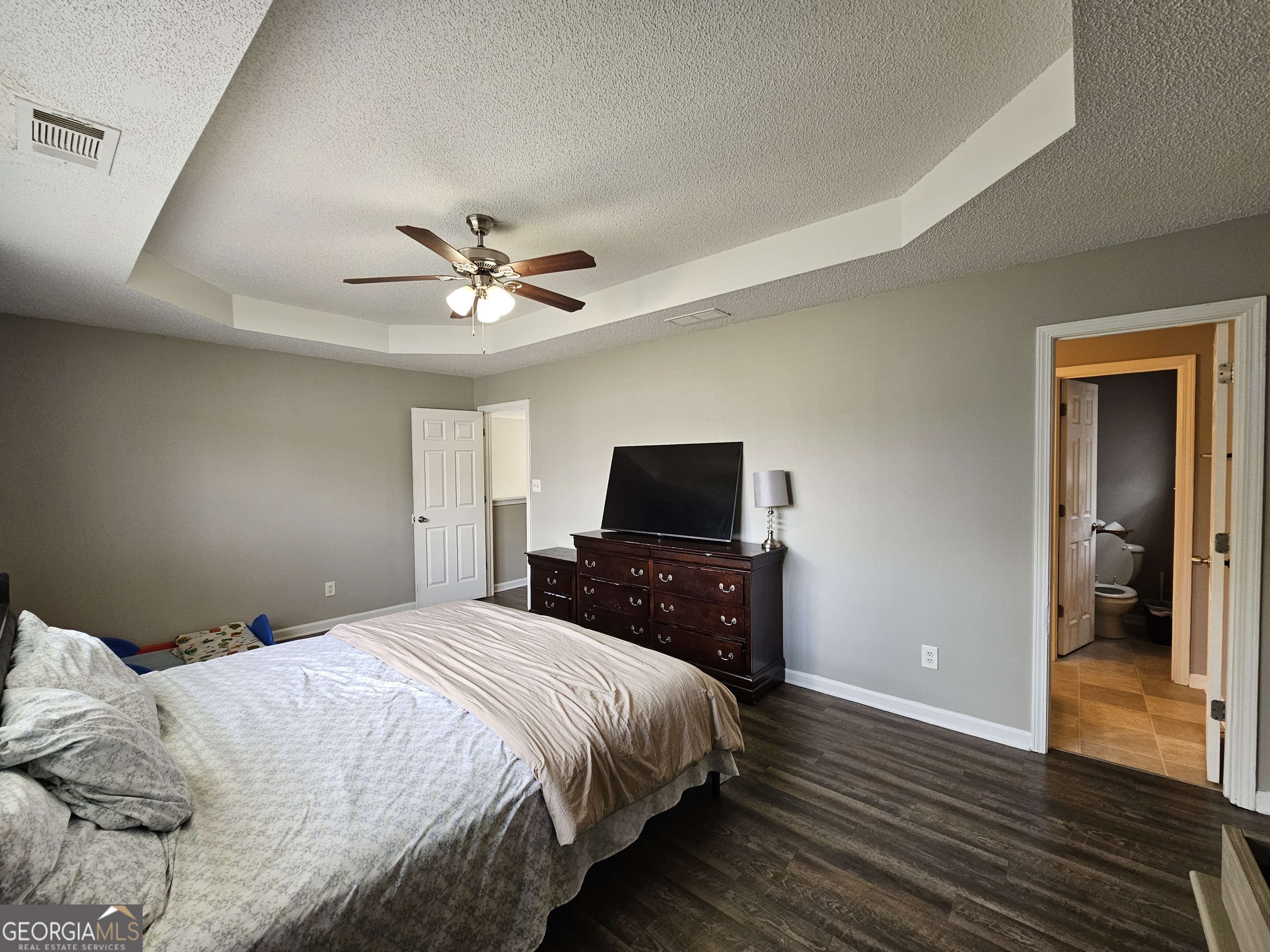 5077 Meadow Trace Fairburn, GA 30213 - Photo 38 of 43 a bedroom with bed tv and wooden floor