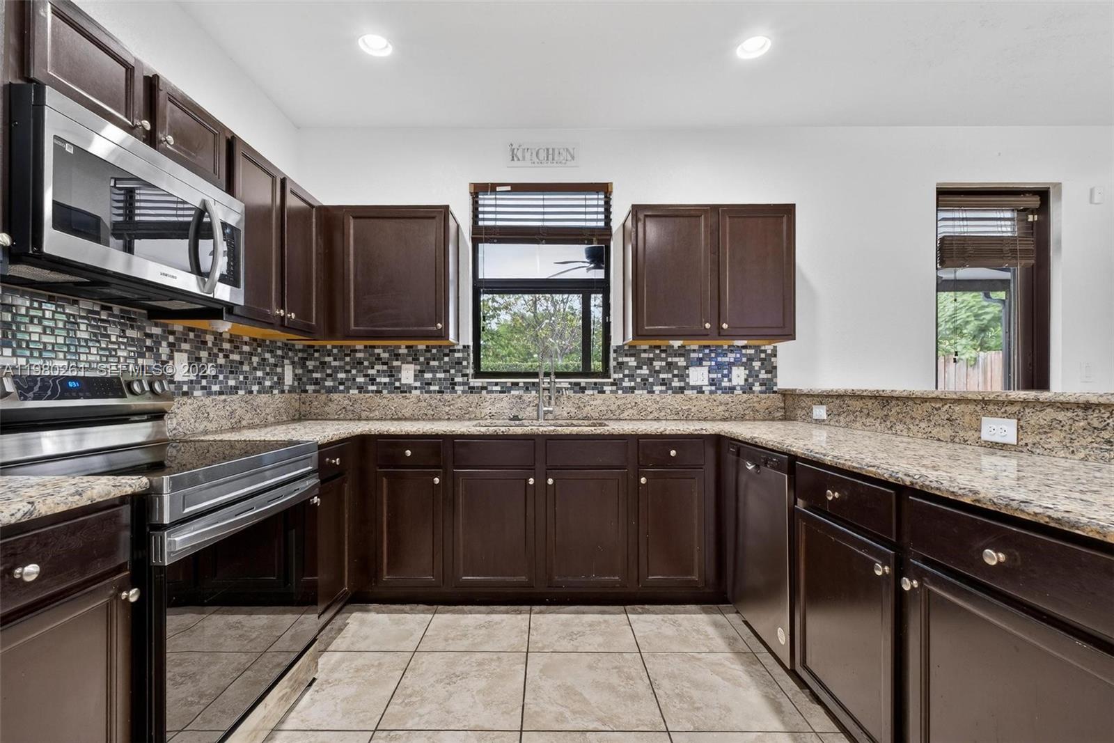 11561 Southwest 232nd Lane Homestead, FL 33032 - Photo 14 of 60 a kitchen with stainless steel appliances granite countertop wooden cabinets and a sink