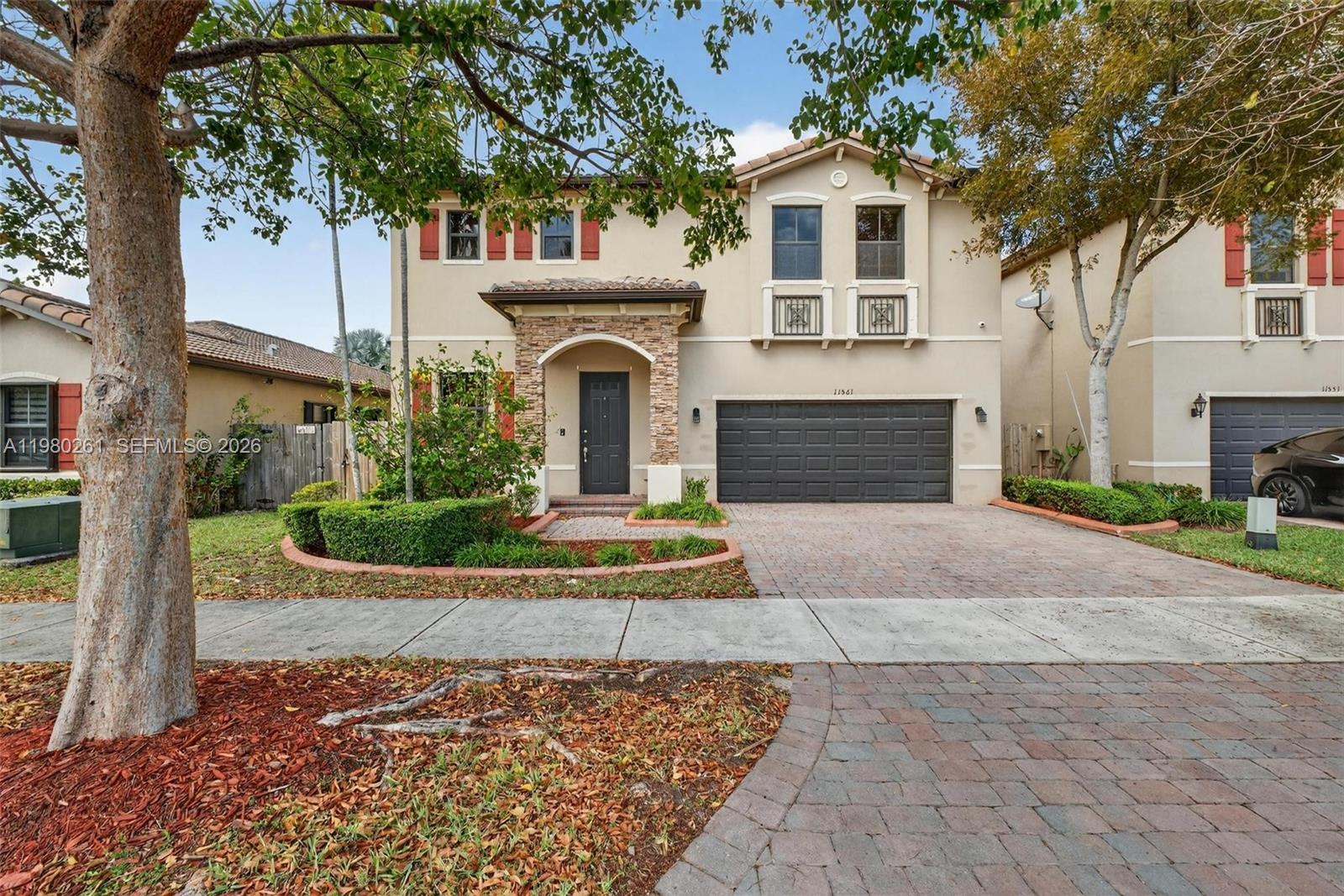 11561 Southwest 232nd Lane Homestead, FL 33032 - Photo 2 of 60 a front view of a house with a yard and garage