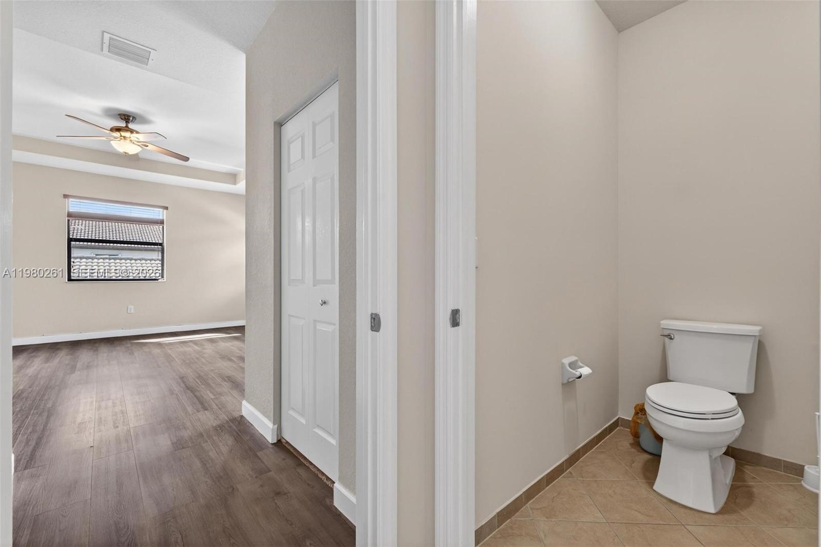 11561 Southwest 232nd Lane Homestead, FL 33032 - Photo 37 of 60 a bathroom with a toilet and a wooden floor