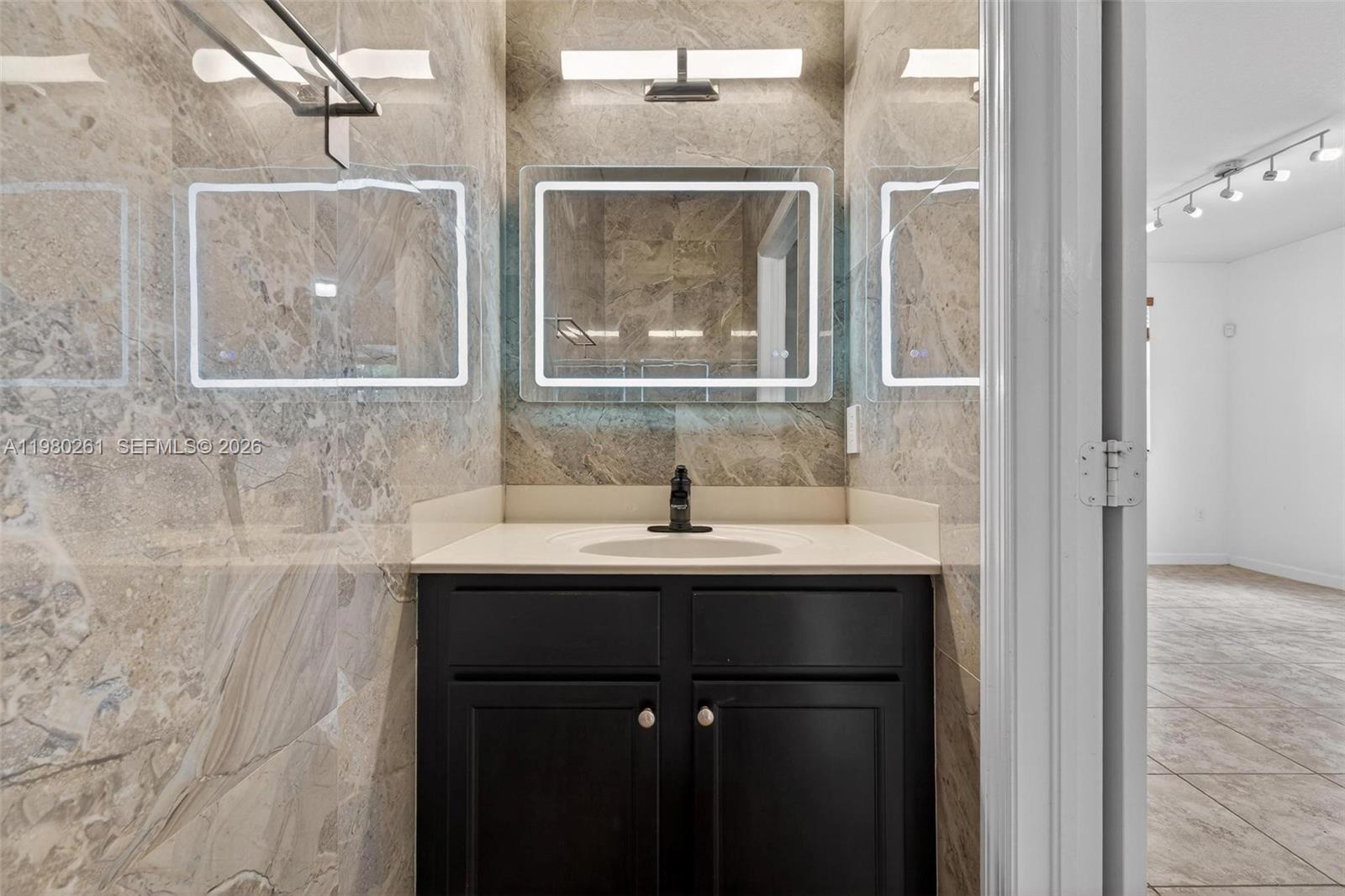 11561 Southwest 232nd Lane Homestead, FL 33032 - Photo 9 of 60 a bathroom with a sink and a mirror