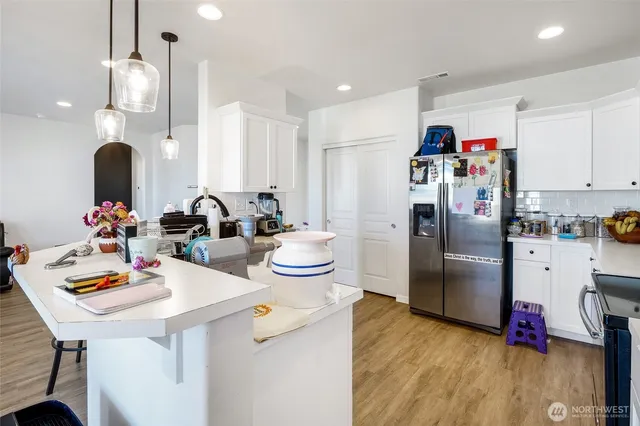 a kitchen with stainless steel appliances granite countertop a sink a stove and a refrigerator