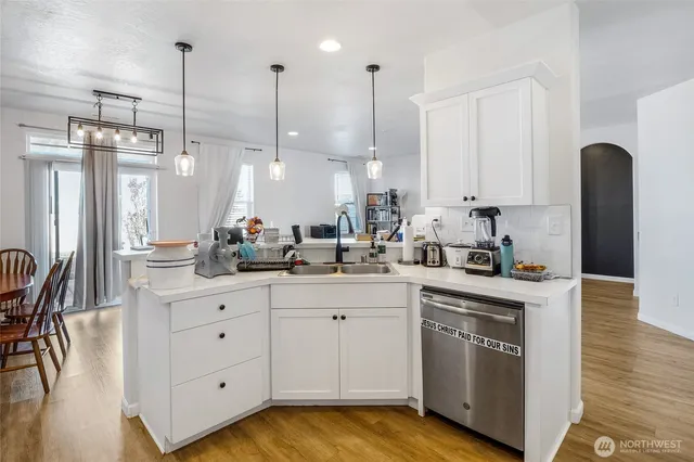 a kitchen with stainless steel appliances kitchen island granite countertop a refrigerator a stove a microwave oven a sink with a dining table and chairs