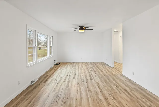 a view of empty room with wooden floor