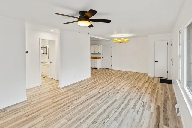a view of a kitchen with wooden floor electronic appliances and furniture