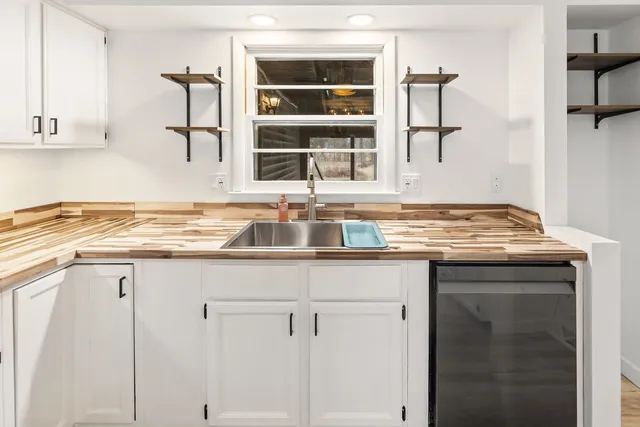 a view of kitchen with granite countertop white cabinets and white appliances