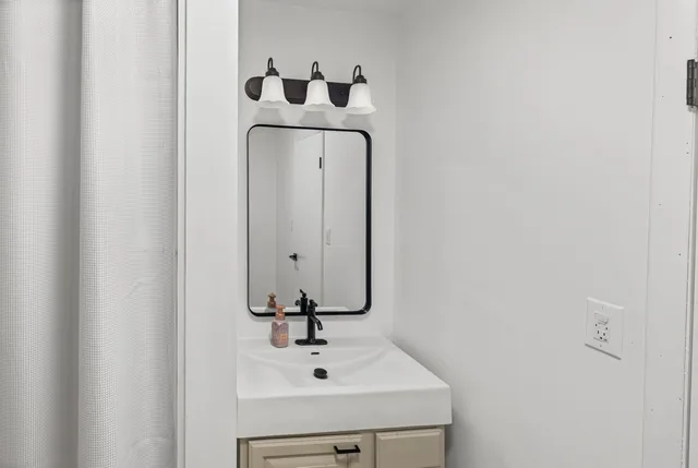 a bathroom with a granite countertop sink and a mirror