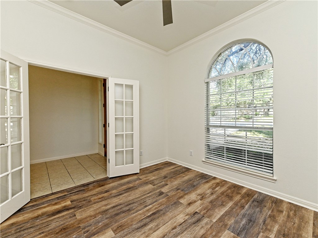 7909 Cobblestone Austin, TX 78735 - Photo 5 of 12 an empty room with wooden floor cabinet and windows