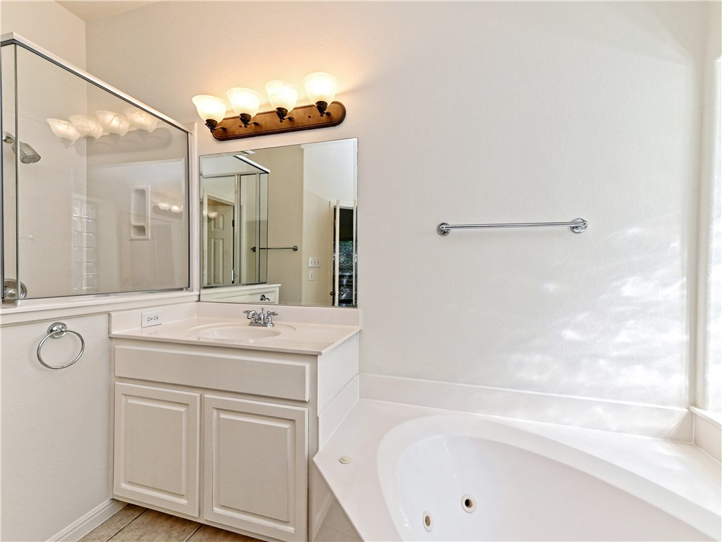 7909 Cobblestone Austin, TX 78735 - Photo 7 of 12 a bathroom with a sink and a mirror with bathtub