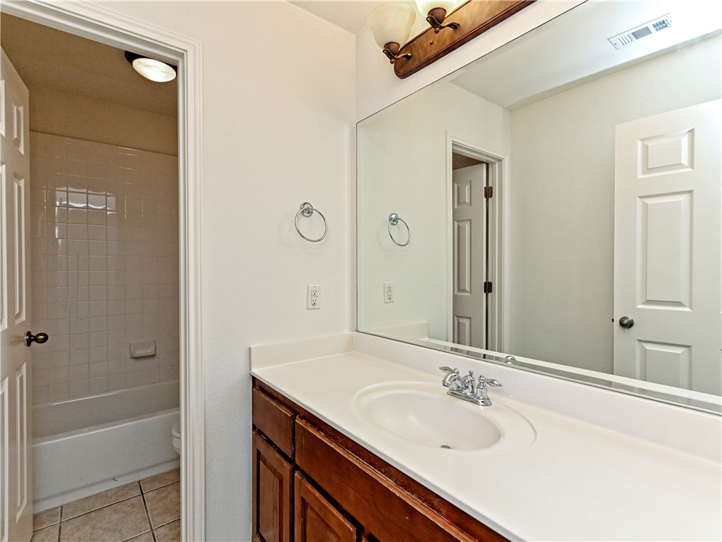 7909 Cobblestone Austin, TX 78735 - Photo 10 of 12 a bathroom with a granite countertop sink a mirror and a bathtub