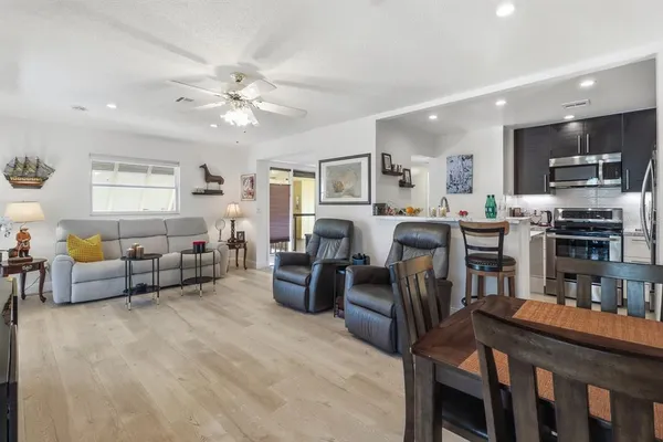 a living room with furniture kitchen view and a fireplace