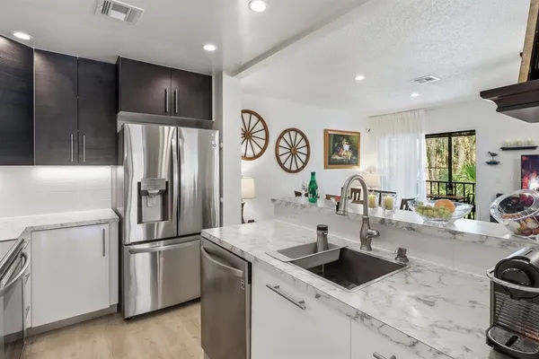 a kitchen with stainless steel appliances granite countertop a refrigerator and a sink