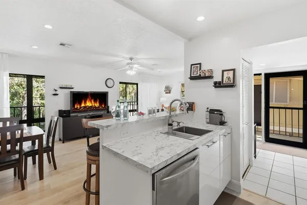 a kitchen with a sink a microwave and chairs