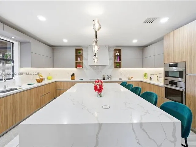 a kitchen with kitchen island a stove and a sink