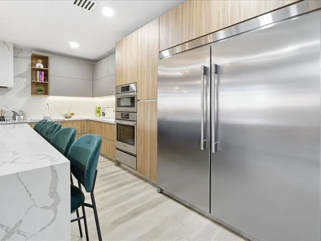 a kitchen with cabinets a refrigerator and a table