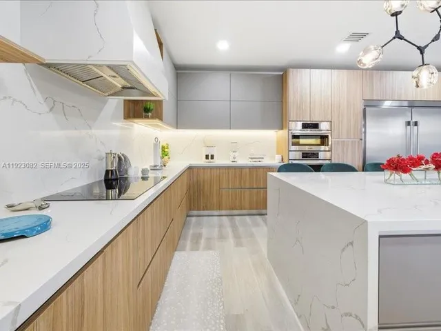 a kitchen with kitchen island a sink a counter space and cabinets