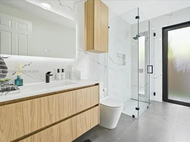 a bathroom with a sink a toilet and shower