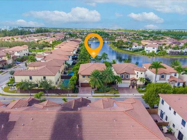 an aerial view of residential houses with outdoor space and ocean view