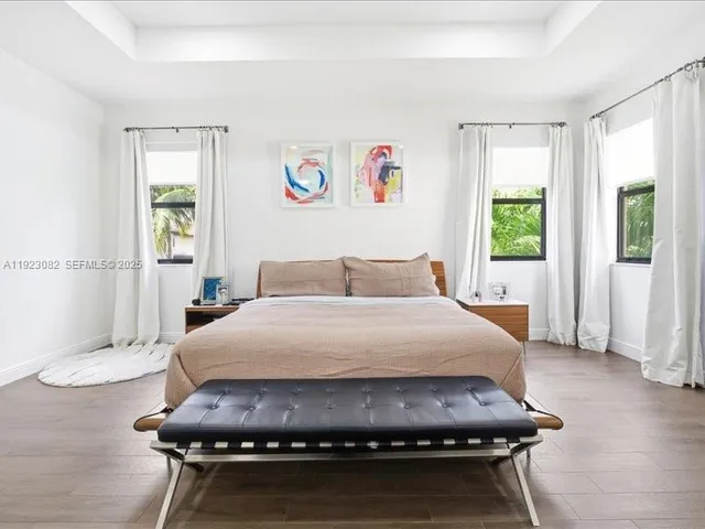 a bedroom with a bed mirror and window